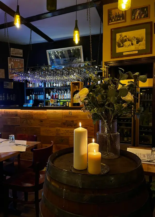 Sala restauracji: świece na beczce, w tle bar