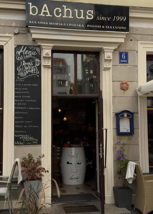 Wejście do restauracji: czarny szyld bAchus, tablica z menu, numer Sienna 6